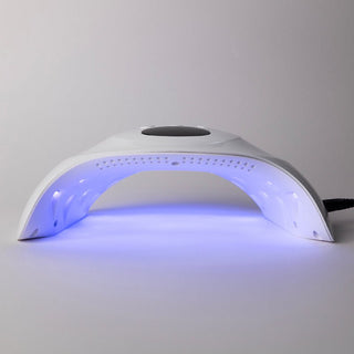 De LAKKIE lamp. Een UV/LED lamp die je gellak snel laat drogen. Met 58 watt is dit een krachtige lamp. Op de bovenkant van de lamp zit de timer knop voor 30, 60 of 99 seconden droogtijd. In het lcd scherm kun je de droog tijd zien, die aftelt.