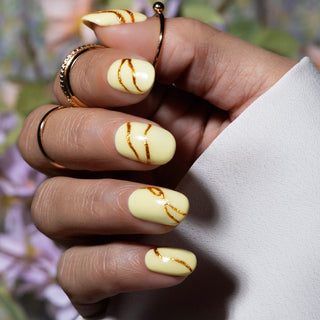 Pastel gele nagels met gouden gellak design